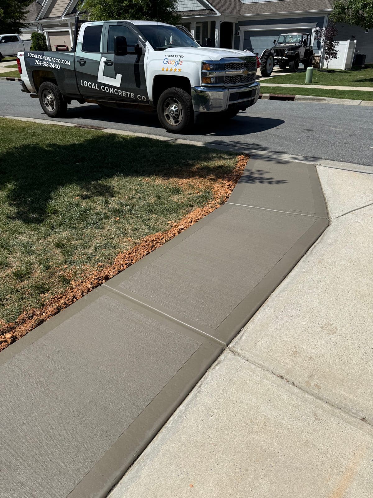 Long concrete driveway in Chapel Hill, NC — extended poured slab, cross-slope drainage, control joints by Local Concrete Contractor.