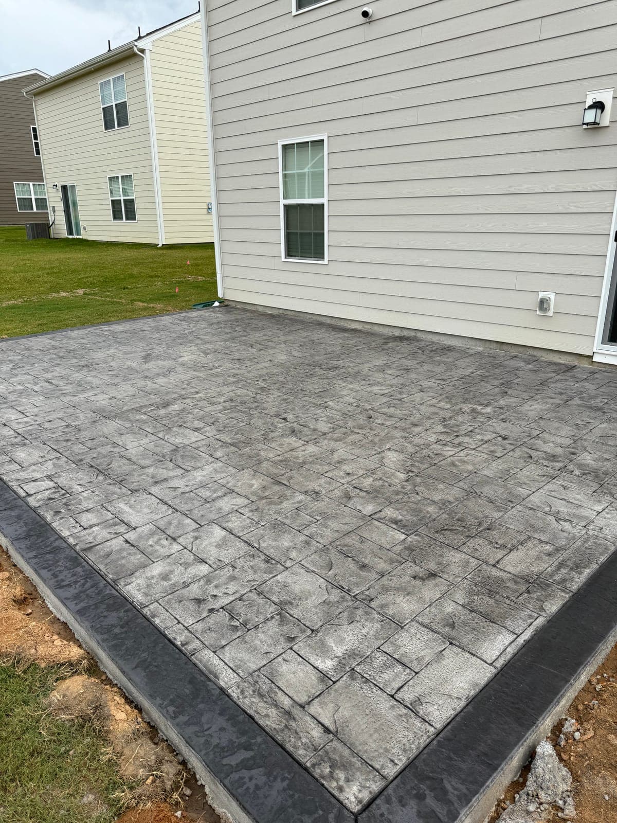 Stamped concrete repair in Clayton, NC — pattern-match patch, color re-tint, resealing by Local Concrete Contractor.