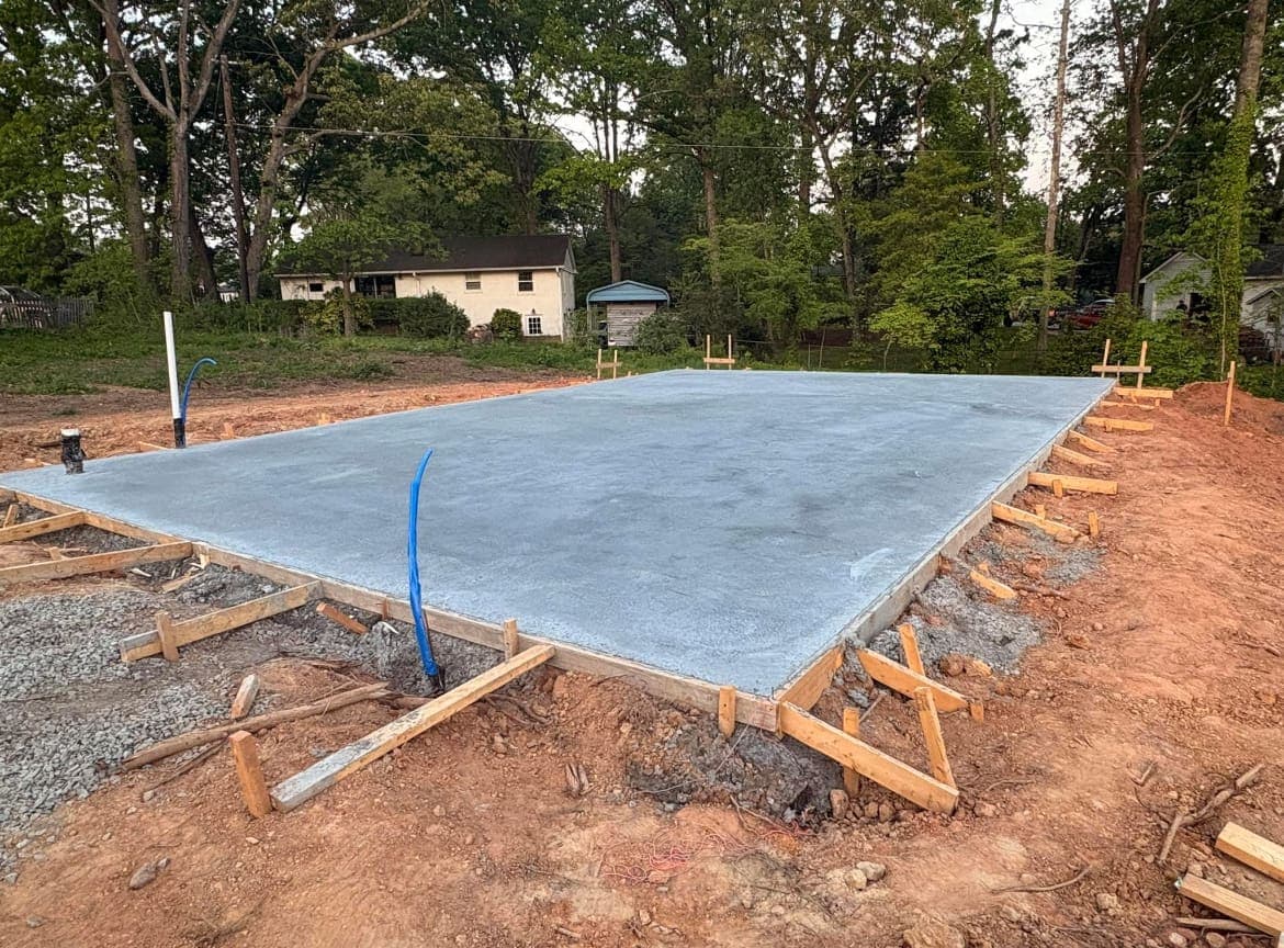 Concrete foundation slab installation in Gastonia, NC — poured footings, control joints, smooth troweled surface by Local Concrete Contractor.